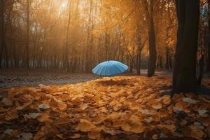 Beautiful autumn background landscape. Carpet of fallen orange autumn leaves in park and blue umbrella. Leaves fly in wind in sunlight. Concept of Golden autumn photo