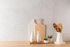 kitchen background in a minimalist form with a set of cutting boards and bottles of oil. wooden table top. grey concrete wall. a copy space. photo