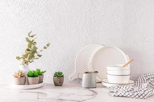 Beautiful kitchen background with various eco-friendly utensils and plants in pots and vases. front view. grey cement wall. a copy space. photo