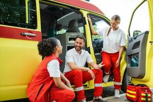 Multi-etnik team of paramedics smiling. Happy paramedics in uniform photo