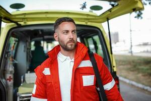 Ambulance staff member emerges from the back of an ambulance with his emergency backpack , and vital signs monitor . photo