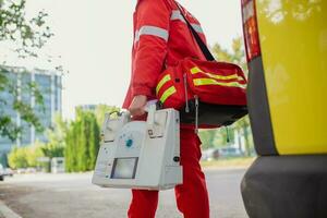 mano de el médico con desfibrilador equipos de el emergencia médico Servicio son respondiendo a un tráfico accidente. foto