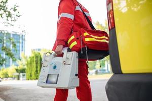 mano de el médico con desfibrilador equipos de el emergencia médico Servicio son respondiendo a un tráfico accidente. foto