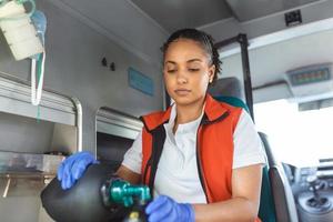 Female EMS Paramedics Provide Medical Help to an Injured Patient on the Way to a Healthcare Hospital. Emergency Care Assistant Putting On Non-Invasive Ventilation Mask in an Ambulance. photo