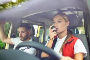 dos paramédicos En t ambulancia. hembra paramédico conducción ambulancia, hablando terminado el radio. urgente situación foto