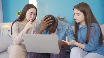 Jeune Université copains de différent ethnies travail sur portable à maison. stressé et nerveux groupe de copains travail sur portable à propos une sujet à maison. africain, asiatique et européen Jeune grouper. video