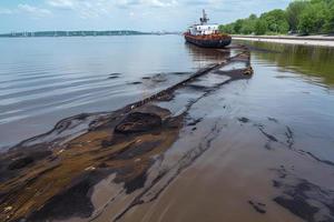 Oil leak from Ship , Oil spill pollution polluted water surface water pollution as a result of human activities photo