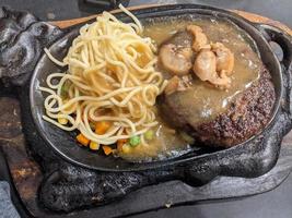 Extra beef steak with noodles and mushroom sauce. The photo is suitable to use for food background, poster and food content media.