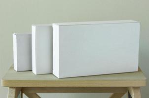 Stack of white cardboard package box mockup on wooden table photo