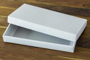 open white cardboard package box mockup on dark wooden table photo