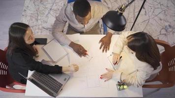 Multiethnic group of colleagues working on project. A group of friends with different ethnic origins, holding a pen in their hands, are working on the Project. video