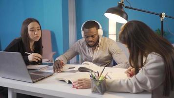 Universiteit studenten van verschillend races studie in harmonie Bij huis. aziatisch, Europese en Afrikaanse Universiteit vrienden studie samen Bij huis. video