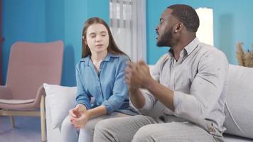 le noir homme est en colère et le sien épouse essaie à calme lui bas. le en colère noir homme est a essayé à calme vers le bas par le sien épouse. argument dans le famille. video