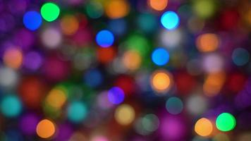 Blurred multicolor lights Happy New Year holiday decorations, colorful abstract blurry bokeh background effect. Out of focus glowing Christmas lights celebration texture for use at graphic design video