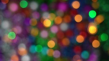 Glowing Xmas sparkling lights balls holiday decorations, abstract blurry bokeh background effect. Defocused colorful Happy New Year lights celebration texture for use graphic design video