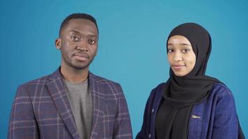 Porträt von afrikanisch jung Muslim Mann und afrikanisch Muslim jung Frau. Muslim afrikanisch jung Mann und jung afrikanisch Frau im Hijab suchen beim Kamera. afrikanisch Muslime. video