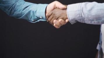 Hand shaking hands in white and black. Close-up handshake of african man and white man.Agreed, greet, meet. video