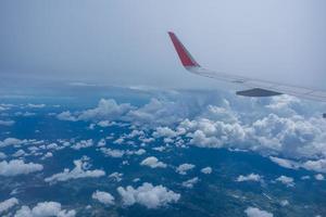 Airplane wing flying above the sky with white clouds. View from aircraft window. flying and traveling concept. photo