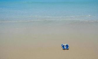 Flip Flops on a sandy ocean beach - Summer vacation concept. photo