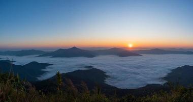 Beautiful landscape on the mountains at sunrise. Spectacular view in foggy valley covered forest under morning sky. Panorama Picture photo