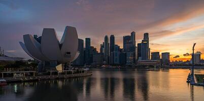 paisaje ver de Singapur negocio distrito y ciudad a crepúsculo. Singapur paisaje urbano a oscuridad edificio alrededor centro de deportes acuáticos bahía. foto