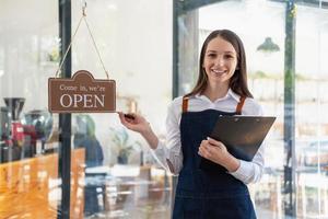 Portrait of a woman, a coffee shop business owner smiling beautifully and opening a coffee shop that is her own business, Small business concept. photo