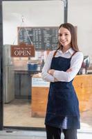 retrato de un mujer, un café tienda negocio propietario sonriente hermosamente y apertura un café tienda ese es su propio negocio, pequeño negocio concepto. foto