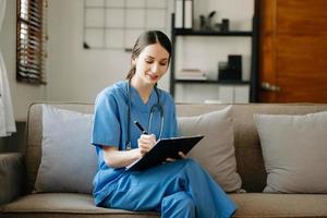 Asian smiling doctor or consultant sitting at a desk his neck looking at the camera photo