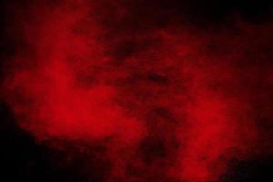 Red powder explosion cloud on black background. photo