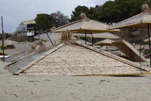 Straw umbrellas on a sandy beach. Straw umbrellas on the sandy beach on the seaside. photo