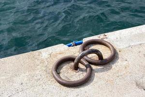 Mooring bollards on the quay of the sea.  Rusty mooring bollard on the dock of the sea photo