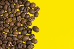 Black coffee beans on yellow background. Left vertical location objects, copy space for text on right photo