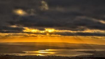 beautiful sun rays from stormy clouds over the lake photo