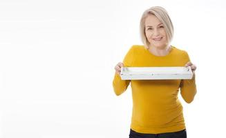 Kitchen woman gives empty tray for your advertising products isolated on white background. Mock up for use photo