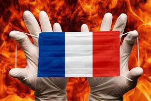 Doctor holding medical face mask with France national country flag superimposed on mask photo