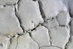 Light gray dry cracked surface of volcanic earth turned into desert photo