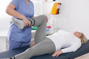 Close-up of famale physiotherapist massaging the leg of patient in a physio room. photo