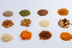 Healthy vegetarian food concept. Assortment of dried fruits, nuts and seeds on white background. Top view. photo