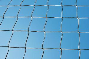 Soccer or football cage texture against blue sky photo