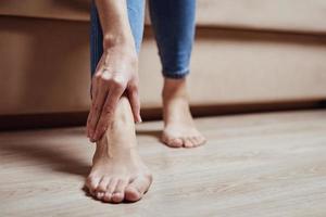 Woman have pain in leg, take ankle massage photo