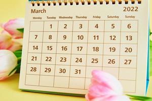 Calendar and flowers on yellow background photo
