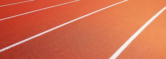 Red running track at stadium with border lanes photo