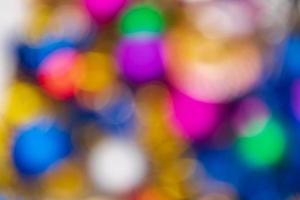 Defocused glowing Xmas balls holiday decorations, abstract blurry bokeh background effect. Out of focus colorful Happy New Year lights celebration texture for use at graphic design photo