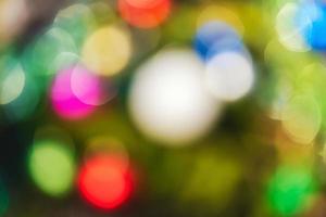 Defocused colorful Christmas holiday decorations, abstract blurry bokeh background effect. Out of focus glowing lights celebration texture for use at graphic design photo