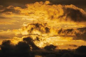 Dramatic clouds illuminated rising of sun in sky to change weather. Natural meteorology background. Majestic cloudscape photo