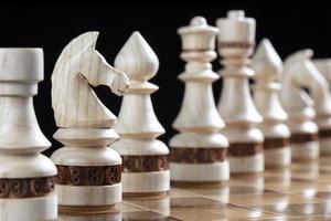 White chess pieces on a chess field. A puzzle game with tricky combinations that requires planning and thinking. photo