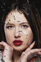 Portrait of a beautiful girl with red lips on a background of torn and crumpled paper. photo