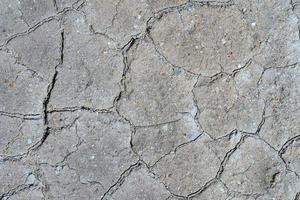 Gray dry cracked surface of volcanic ground turned into desert photo