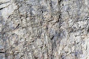 Cracked stone surface grey color. Detailed nature background or pattern texture photo