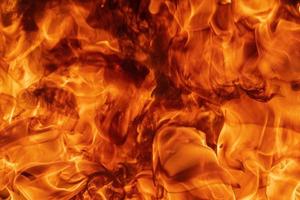 flameante resumen natural rojo fuego llamas textura o antecedentes. hermosa peligroso movimiento borroso vapores foto